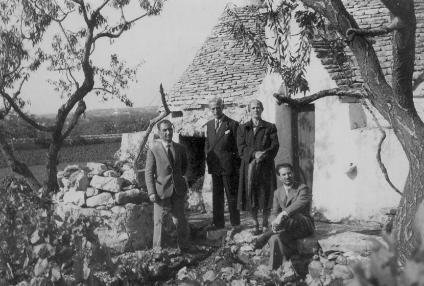 Franco, his parents and brother in front of a trullo, a typical Apulian stone dwelling.