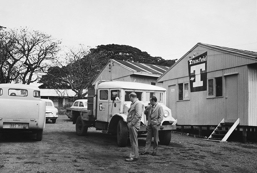 1956. Giancarlo Cecchini inspects a vehicle at the Port Kembla Hostel.